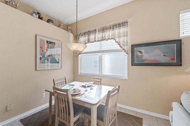 dining room featuring baseboards, tile patterned flooring, and a healthy amount of sunlight