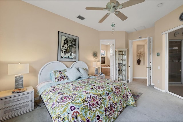carpeted bedroom with baseboards, visible vents, ensuite bathroom, and a ceiling fan