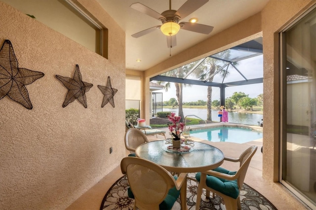 sunroom featuring a water view and ceiling fan