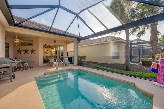 outdoor pool featuring a lanai, ceiling fan, and a patio area