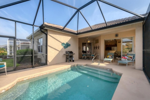 outdoor pool featuring glass enclosure, a grill, and a patio
