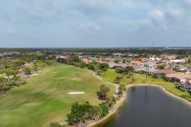 drone / aerial view featuring a water view, view of golf course, and a residential view