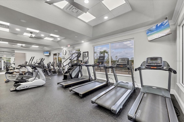 exercise room with recessed lighting, a tray ceiling, baseboards, and visible vents