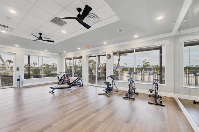 gym featuring ceiling fan, visible vents, crown molding, and wood finished floors