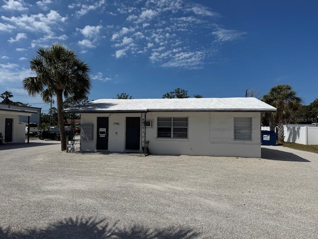 ranch-style home with stucco siding and fence
