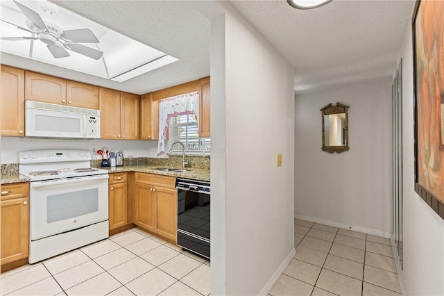 kitchen featuring a sink, light stone countertops, baseboards, light tile patterned floors, and white appliances