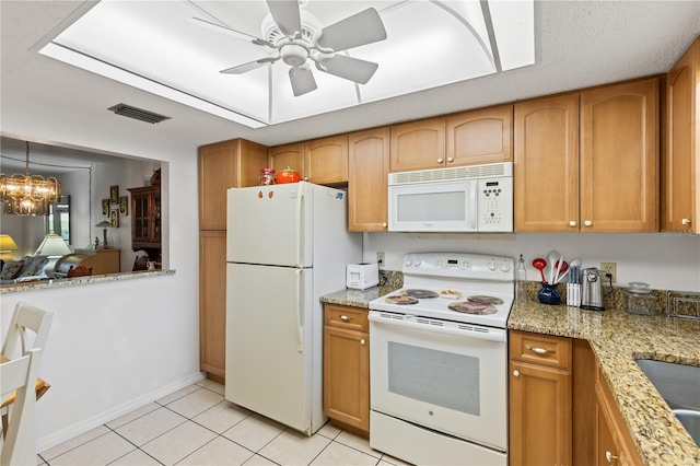 kitchen with brown cabinets, visible vents, light tile patterned floors, and white appliances