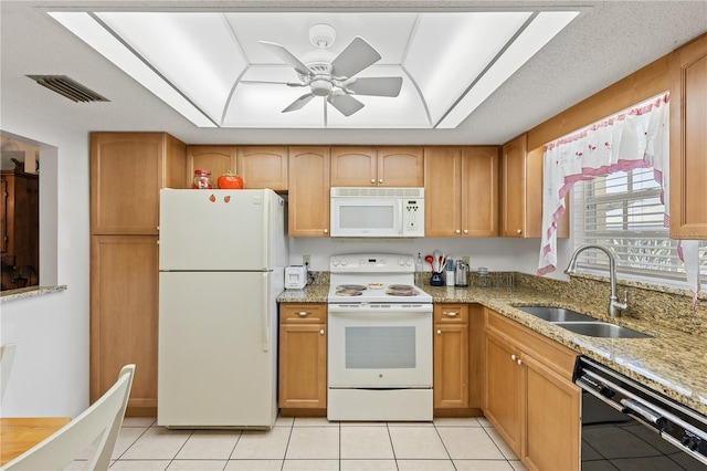 kitchen featuring a sink, a raised ceiling, light tile patterned floors, white appliances, and visible vents
