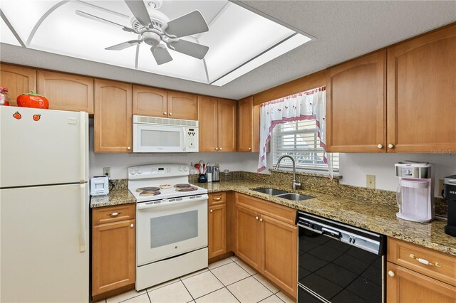 kitchen with light tile patterned flooring, a sink, a ceiling fan, light stone countertops, and white appliances