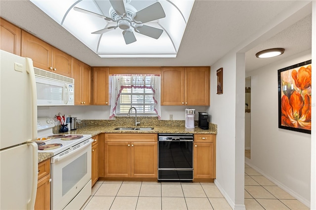 kitchen featuring white appliances, light tile patterned floors, a raised ceiling, a sink, and light stone counters