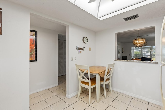 dining area with baseboards, visible vents, a chandelier, and light tile patterned floors