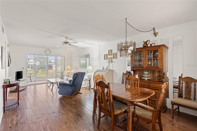 dining area featuring wood finished floors and ceiling fan with notable chandelier