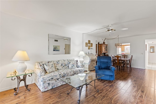 living area featuring baseboards, wood finished floors, and a ceiling fan