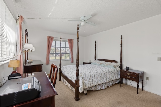 carpeted bedroom featuring ceiling fan and a textured ceiling