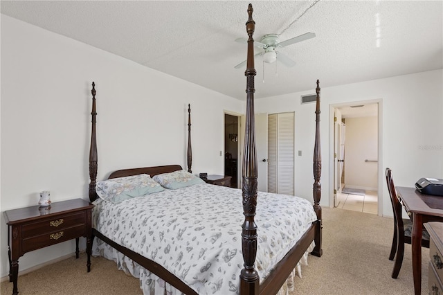 bedroom featuring a closet, a textured ceiling, visible vents, connected bathroom, and light carpet