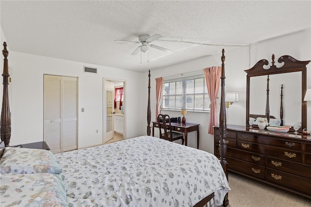 carpeted bedroom featuring connected bathroom, visible vents, ceiling fan, and a textured ceiling