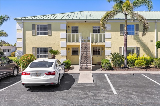view of property featuring uncovered parking and stairway