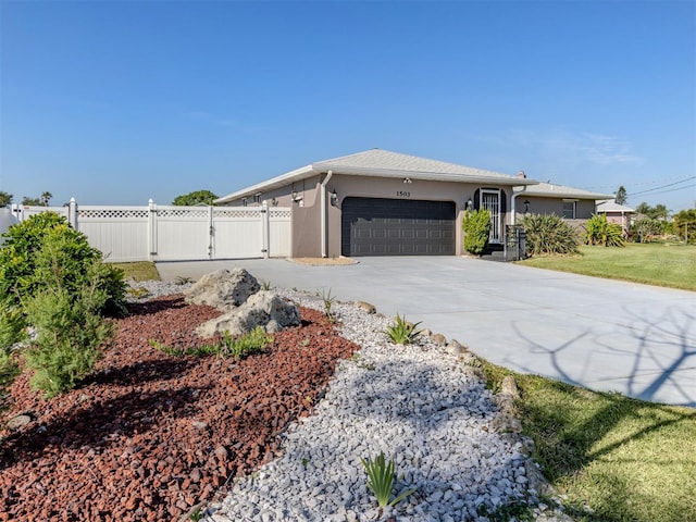 view of side of property with driveway, a gate, stucco siding, fence, and an attached garage