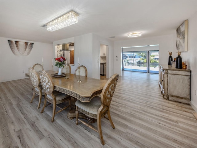 dining area with visible vents and light wood finished floors