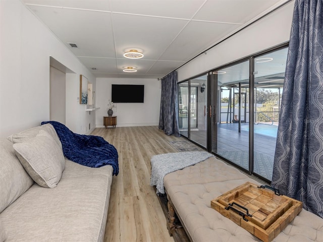 bedroom featuring baseboards, visible vents, wood finished floors, and access to outside