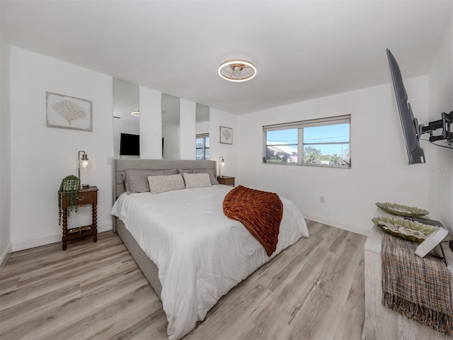 bedroom featuring baseboards and light wood-type flooring