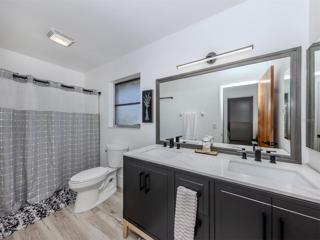 bathroom featuring toilet, a sink, double vanity, and visible vents