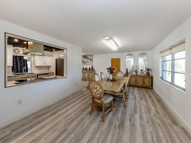 dining space featuring light wood finished floors, baseboards, and visible vents