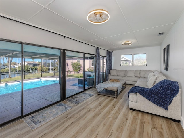 living area with visible vents, wood finished floors, and a healthy amount of sunlight