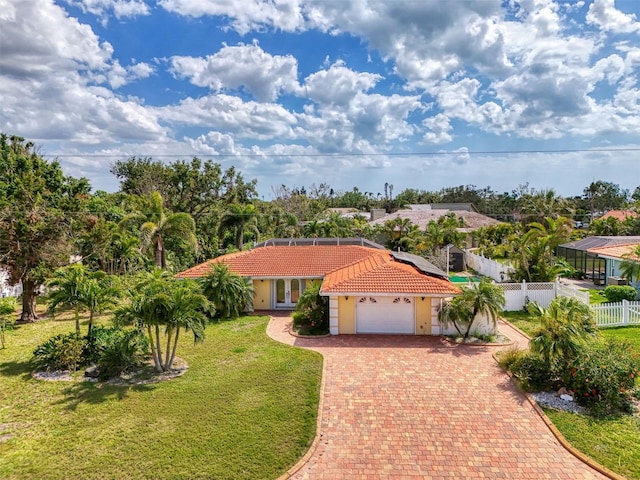 403 Picasso Dr, Nokomis, FL 34275 - mediterranean / spanish-style home featuring a tile roof, stucco siding, fence, an attached garage, and a front lawn