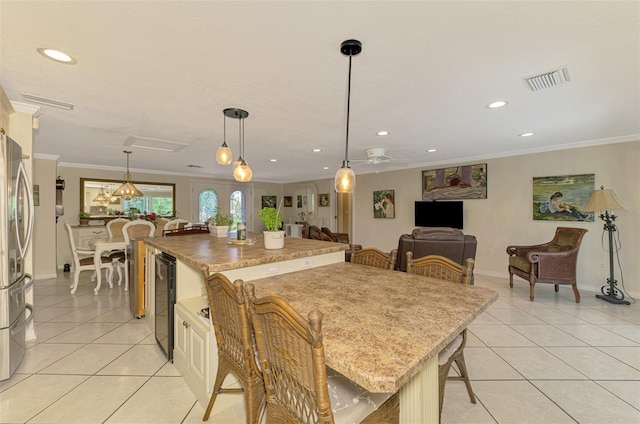 403 Picasso Dr, Nokomis, FL 34275 - kitchen featuring light tile patterned flooring, visible vents, ornamental molding, wine cooler, and freestanding refrigerator