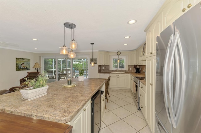 403 Picasso Dr, Nokomis, FL 34275 - kitchen featuring decorative backsplash, a kitchen island, crown molding, and appliances with stainless steel finishes
