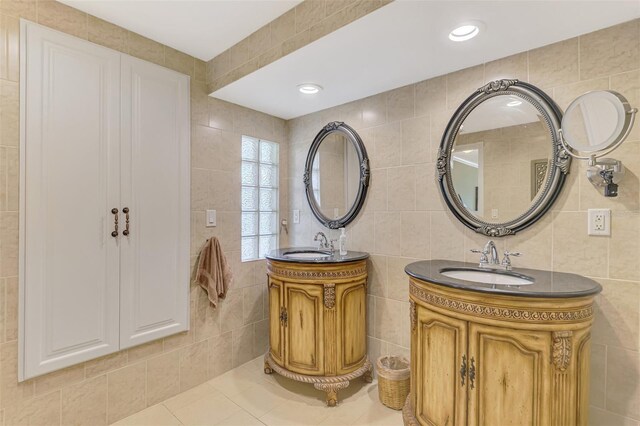 403 Picasso Dr, Nokomis, FL 34275 - bathroom featuring a sink, tile patterned floors, tile walls, and two vanities