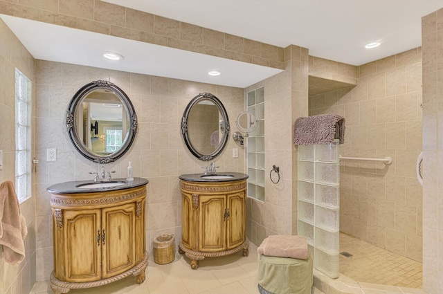 403 Picasso Dr, Nokomis, FL 34275 - bathroom with tile walls, tile patterned floors, two vanities, a sink, and a walk in shower