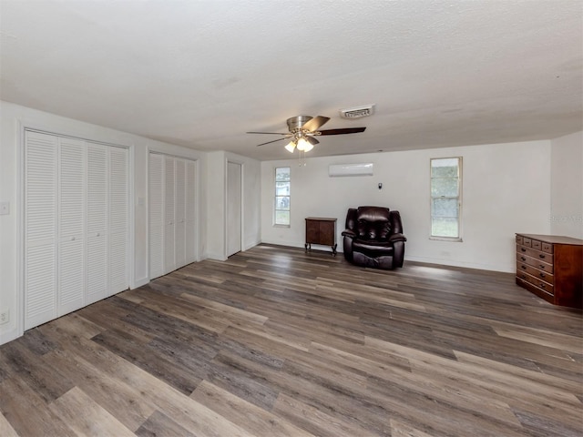 200 Sierra St S, Nokomis, FL 34275 - unfurnished living room with an AC wall unit, baseboards, visible vents, a ceiling fan, and wood finished floors