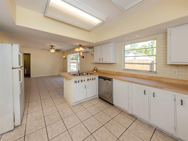 200 Sierra St S, Nokomis, FL 34275 - kitchen with decorative backsplash, a sink, stainless steel dishwasher, light tile patterned floors, and freestanding refrigerator
