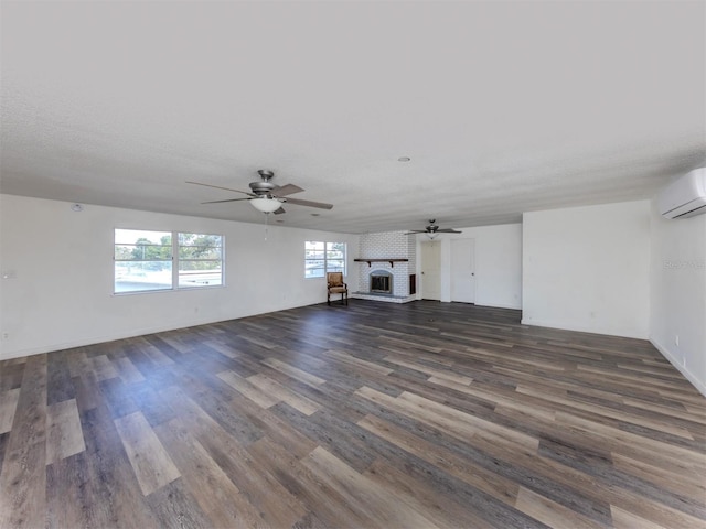 200 Sierra St S, Nokomis, FL 34275 - unfurnished living room featuring a fireplace, a wall mounted air conditioner, dark wood-type flooring, and a ceiling fan