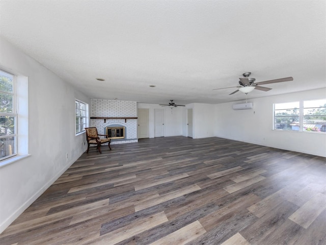200 Sierra St S, Nokomis, FL 34275 - unfurnished living room with a brick fireplace, a wall unit AC, a healthy amount of sunlight, and ceiling fan