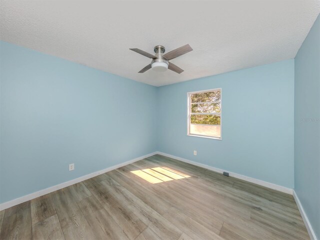 200 Sierra St S, Nokomis, FL 34275 - empty room featuring baseboards, a textured ceiling, ceiling fan, and wood finished floors