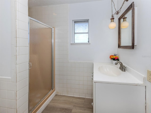 200 Sierra St S, Nokomis, FL 34275 - full bathroom with a stall shower, wood finished floors, vanity, and tile walls