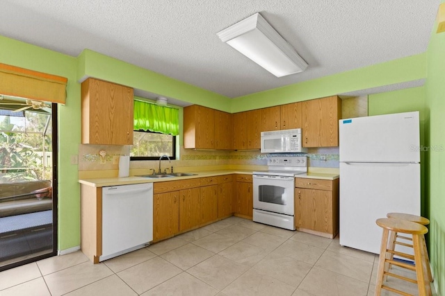 888 Kimball Rd, Venice, FL 34293 - kitchen featuring light tile patterned flooring, light countertops, a sink, and white appliances