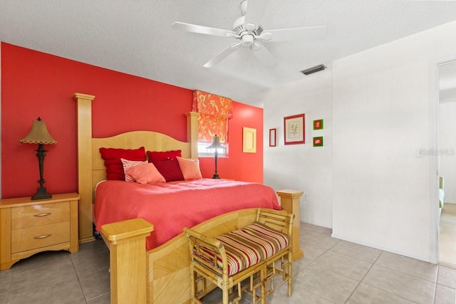 888 Kimball Rd, Venice, FL 34293 - bedroom with light tile patterned floors, an accent wall, a textured ceiling, ceiling fan, and visible vents