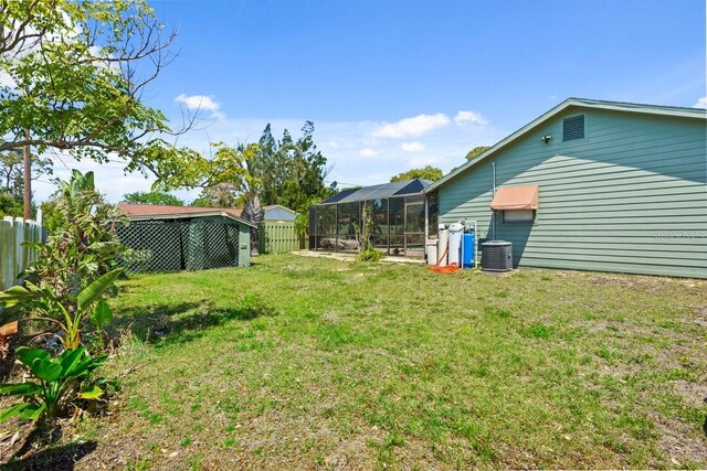888 Kimball Rd, Venice, FL 34293 - view of yard featuring a fenced backyard, glass enclosure, and central AC unit