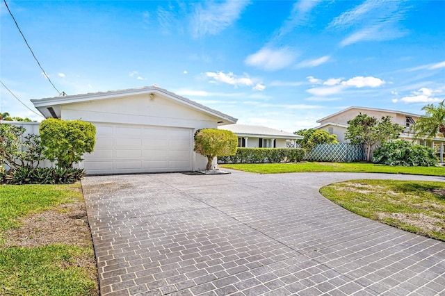ranch-style house with an attached garage, fence, stucco siding, and curved driveway