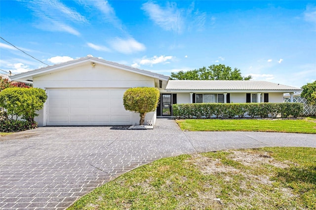 ranch-style house with stucco siding, a front lawn, decorative driveway, and a garage