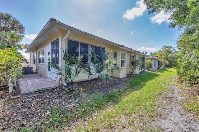 121 Auburn Woods Cir, Venice, FL 34292 - view of home's exterior featuring cooling unit, stucco siding, a patio area, and a yard