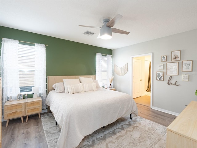 4907 Wedgeleaf Way, Palmetto, FL 34221 - bedroom with a ceiling fan, baseboards, wood finished floors, ensuite bathroom, and visible vents