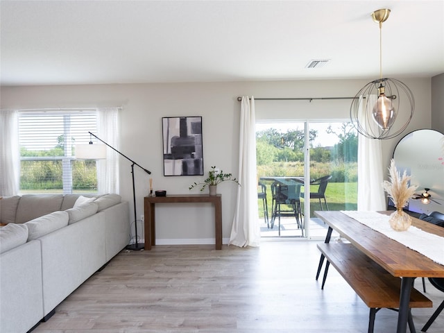 4907 Wedgeleaf Way, Palmetto, FL 34221 - living area featuring baseboards, visible vents, a healthy amount of sunlight, and light wood finished floors