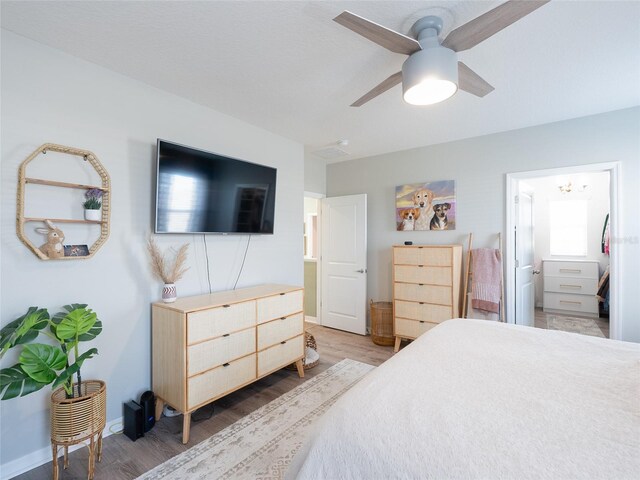 4907 Wedgeleaf Way, Palmetto, FL 34221 - bedroom with baseboards, a ceiling fan, light wood-type flooring, and ensuite bath