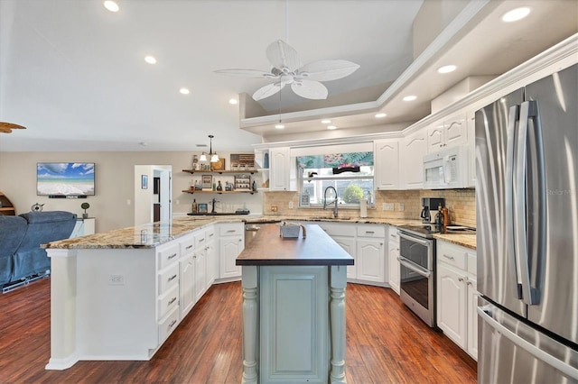 4305 Sandune Ave, North Port, FL 34287 - kitchen with stainless steel appliances, ceiling fan, white cabinets, backsplash, and open shelves