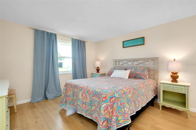 bedroom featuring baseboards and wood finished floors